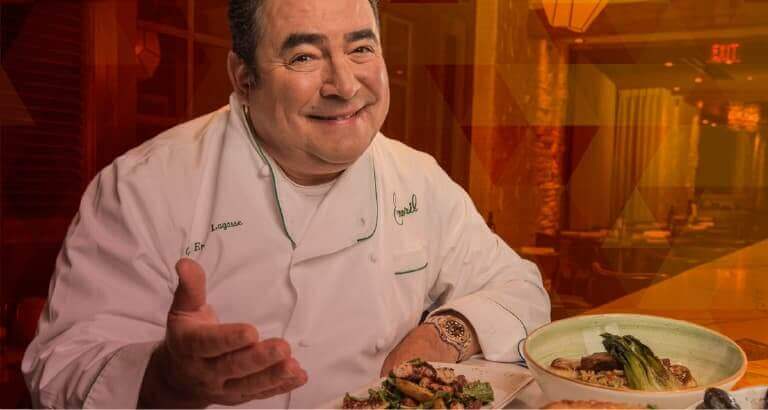 Chef Emeril Lagasse smiling and presenting a dish
